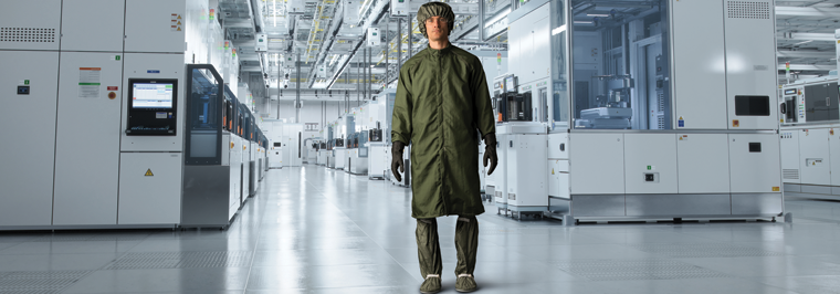 Employee in controlled environment donning proper cleanroom gowning